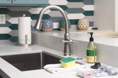 a kitchen sink with a faucet and detergents at Sunny on the Ocean - Beachfront- Pacific Beach in San Diego