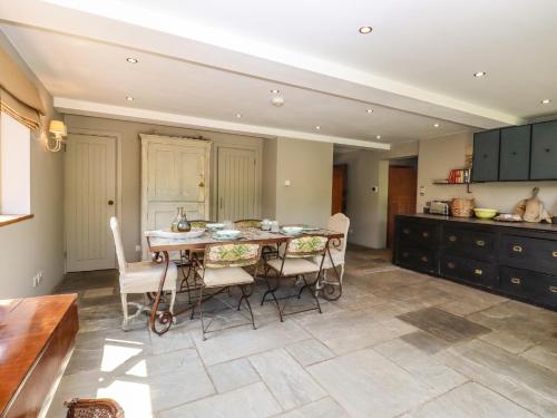 a kitchen with a dining room table and chairs at Six Acres House in Rye