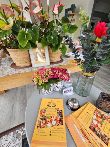 a table with books and flowers and plants at The Old Cable Historic House & Seafood Restaurant in Waterville