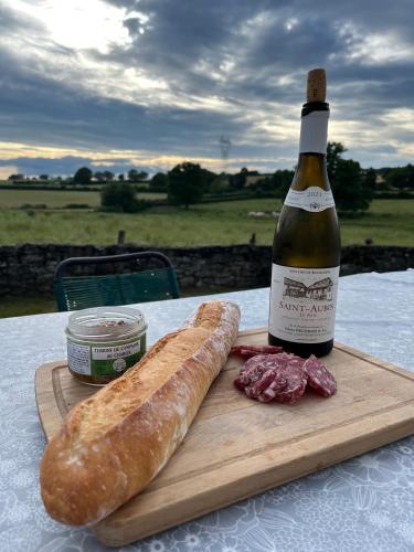 - une bouteille de vin et un pain sur une table dans l'établissement Les Ecureuils, chambre au calme, à Bussy-la-Pesle
