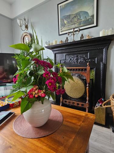 a vase with flowers on a table in a living room at The Old Cable Historic House & Seafood Restaurant in Waterville