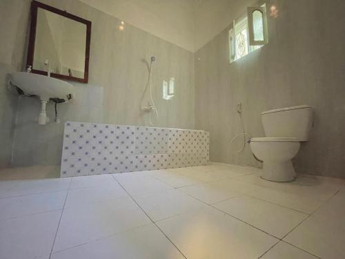 La salle de bains est pourvue de toilettes, d'une baignoire et d'un lavabo. dans l'établissement Green's Nungwi, à Nungwi