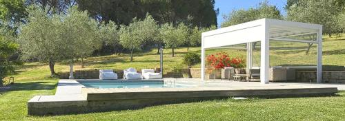 einem Pavillon mit Stühlen und einem Pool auf einem Feld in der Unterkunft Casale Carla in Impruneta