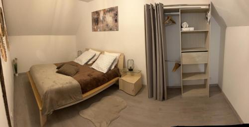 ein kleines Schlafzimmer mit einem Bett und einem Bücherregal in der Unterkunft Le Gai Lo Gite in Villers-Pol