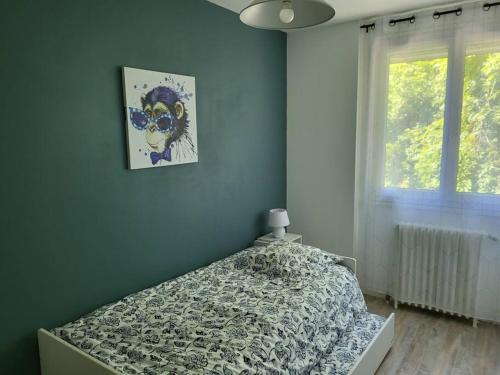 1 dormitorio con 1 cama y una foto en la pared en La maison des Sablons, en Chartres