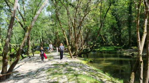 a group of people walking down a path near a river at Quinta do Paúl de Baixo in Guimarães