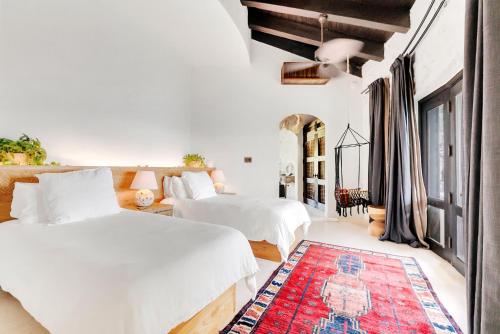 a bedroom with two beds and a red rug at The Aerial, BVI in Tortola Island