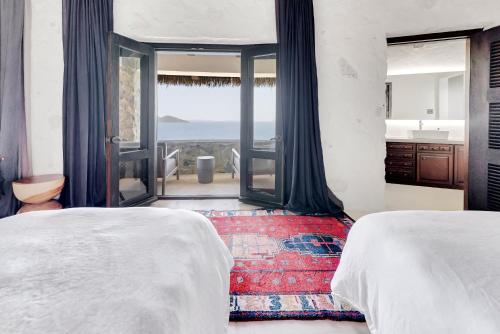 two beds in a bedroom with a view of the ocean at The Aerial, BVI in Tortola Island