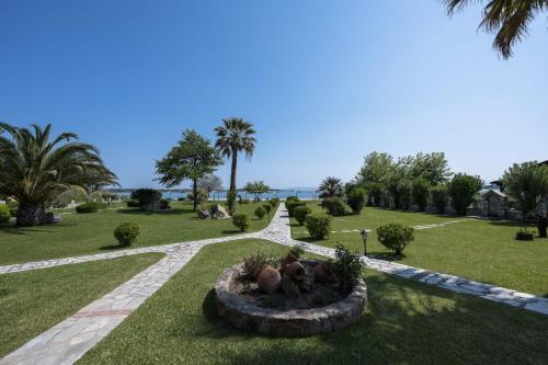 a park with palm trees and a pathway at studios ioanna in Vourvourou