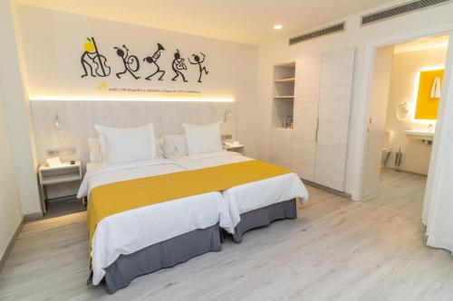 1 dormitorio con 1 cama grande con manta amarilla en Lemon & Soul Las Palmas en Las Palmas de Gran Canaria