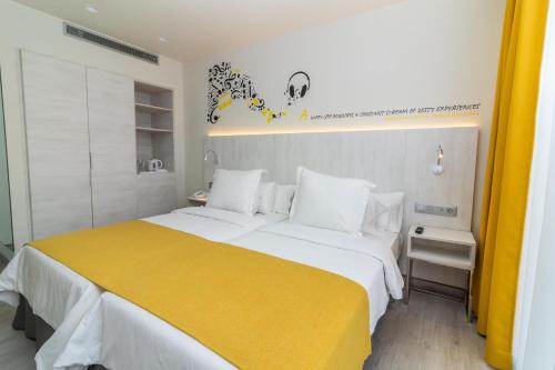 a bedroom with a large bed with a yellow blanket at Lemon & Soul Las Palmas in Las Palmas de Gran Canaria