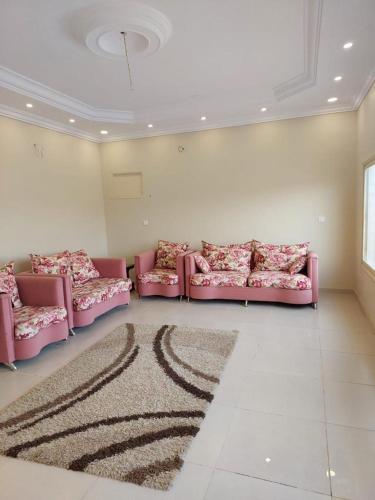 a living room with pink couches and a rug at استراحة في منطقة مرتفعة بالقرب من أبها in Abha