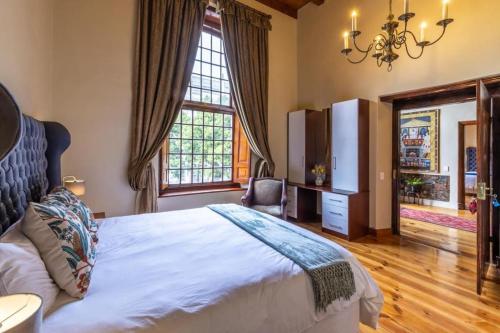 a bedroom with a bed and a large window at Cape Town Heritage Hotel & Spa in Cape Town