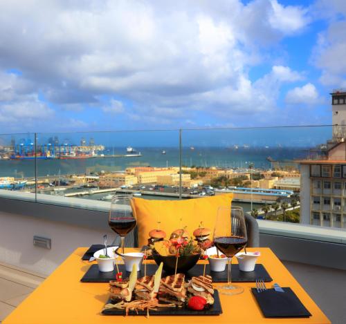 a table with wine glasses and a view of the ocean at Design Plus Bex Hotel in Las Palmas de Gran Canaria