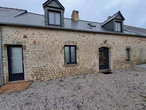 une maison en briques avec des fenêtres et un toit dans l'établissement Au P’tit Bijou, à Sainte-Mère-Église