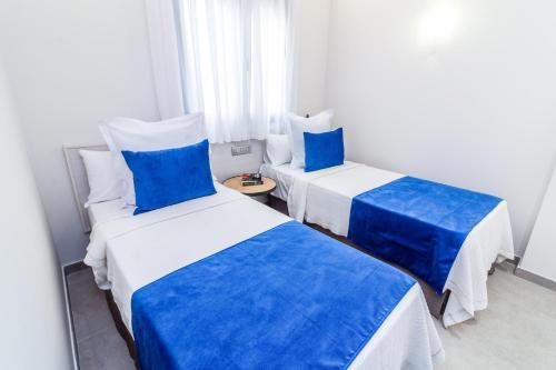 Dos camas en una habitación con azul y blanco. en Bex Holiday Homes, en Las Palmas de Gran Canaria