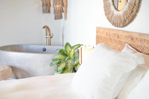 a bathroom with a bath tub and a bed at The Aerial, BVI in Tortola Island