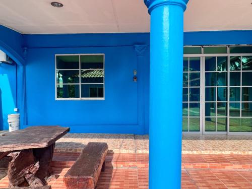 a blue house with a wooden bench in front of it at Padang Besar Homestay Firdaus in Padang Besar
