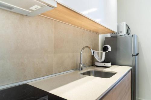 a kitchen with a sink and a refrigerator at BW VERDE DREAM in Sajmište