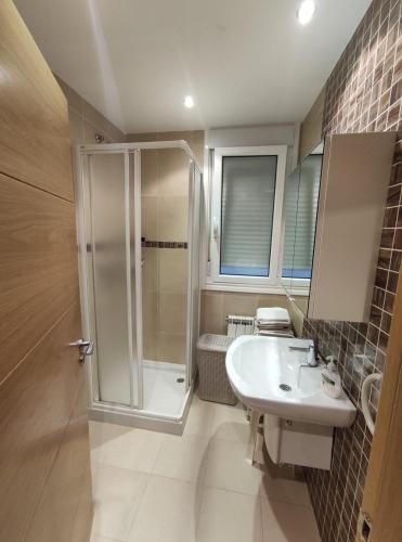 ein Bad mit einer Dusche und einem Waschbecken in der Unterkunft Apartamento A Rapadoira Foz in Foz