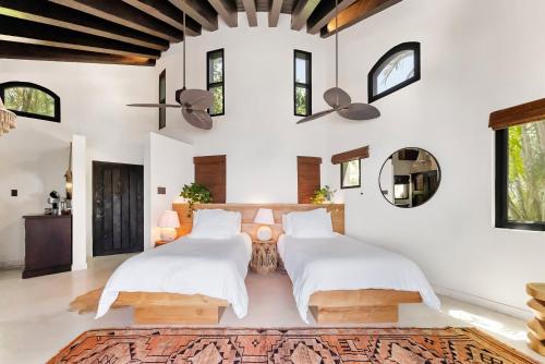 two beds in a room with white walls and windows at The Aerial, BVI in Tortola Island