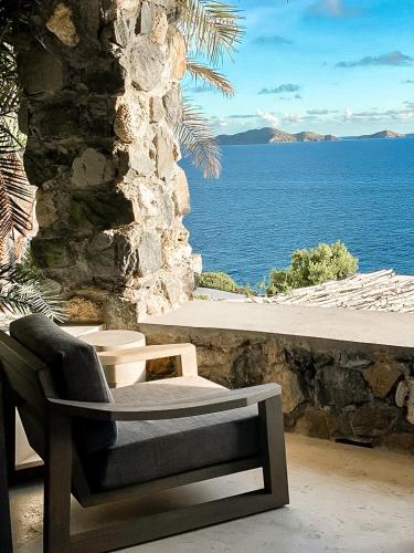 a chair sitting on a patio with a view of the ocean at The Aerial, BVI in Tortola Island