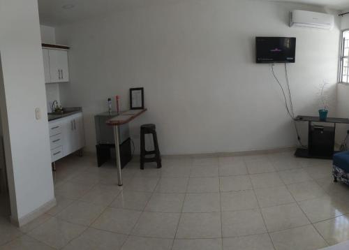 a white room with a table and a kitchen at APARTAESTUDIO SENDERO PRIMAVERA 2 in Neiva