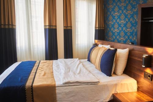 a bedroom with a bed with blue walls and curtains at Seven Dreams Hotel in Istanbul