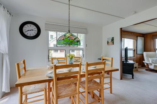 a dining room with a table and chairs and a clock at Vibrant Waterfront Vacation Rental on Lake Huron! in Tawas City