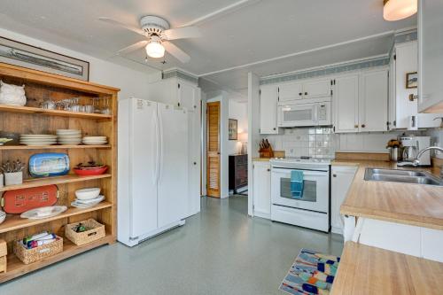 a kitchen with white cabinets and a white refrigerator at Vibrant Waterfront Vacation Rental on Lake Huron! in Tawas City