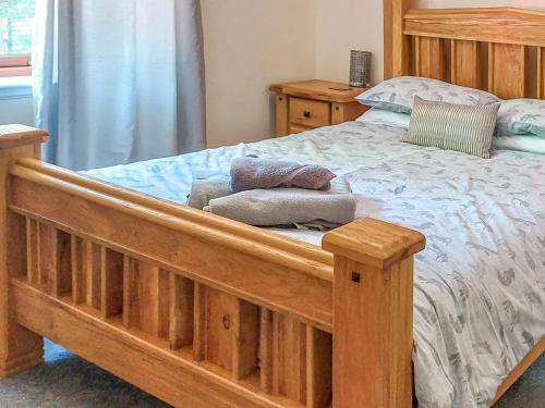 a bedroom with a wooden bed with towels on it at Mountshade in Finzean