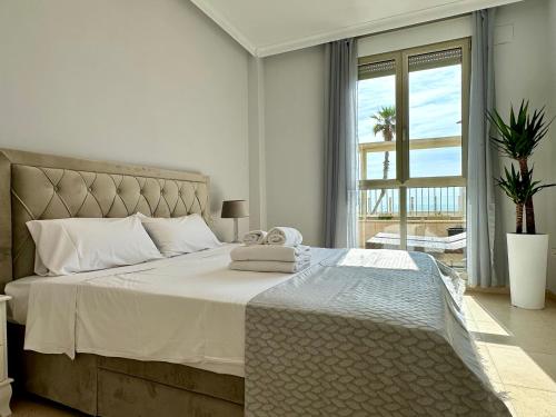 a bedroom with a large bed with a large window at Reinapart Patacona Beachfront Seaview in Valencia