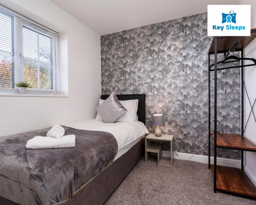 ein kleines Schlafzimmer mit einem Bett und einem Fenster in der Unterkunft Key Sleeps - Private Parking - Lower Pilsley - Balcony - Contractors - Leisure in Pilsley