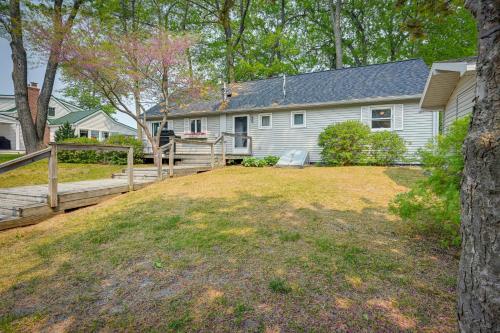 a white house with a wooden fence and a yard at Vibrant Waterfront Vacation Rental on Lake Huron! in Tawas City