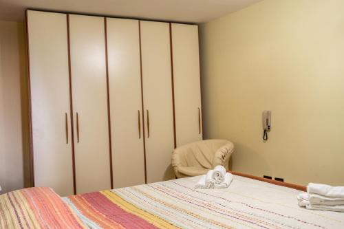 a bedroom with a bed and a chair and cabinets at Casa Donna Grazia - Cilento in Orria