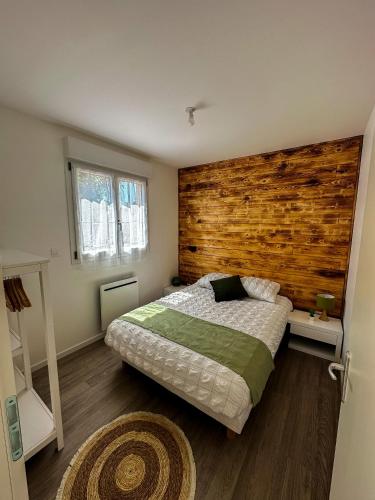une chambre avec un lit et un mur en bois dans l'établissement El Rio Champenois, à Châlons-en-Champagne