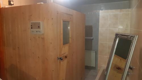baño con puerta de madera y espejo en Traum-Ferienwohnung direkt am Meer en Alcossebre