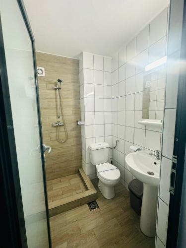 a bathroom with a shower and a toilet and a sink at Hotel Gloria in Eforie Sud