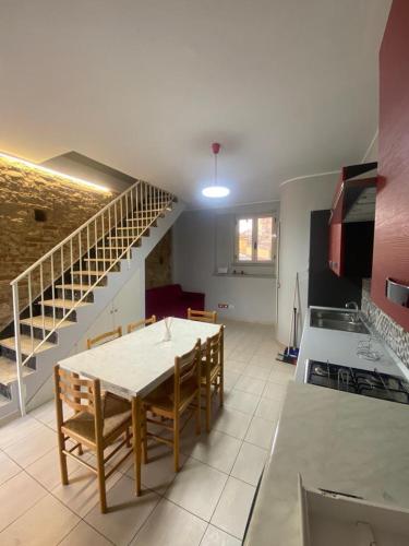 uma cozinha e sala de jantar com uma mesa e uma escada em B&B Mura 17 em Polistena