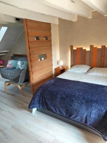 a bedroom with a bed and a chair in it at La Brousse Kacha in Malleret-Boussac