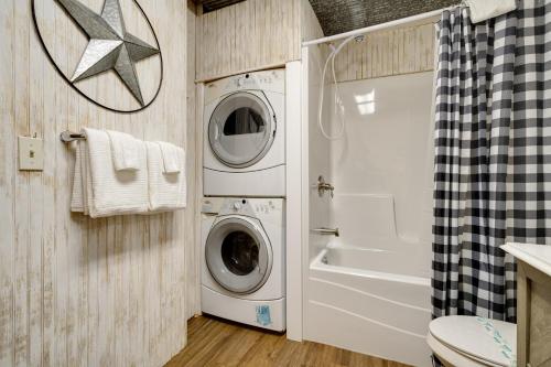 a bathroom with a washer and dryer next to a toilet at A Little Leeway in Ellijay