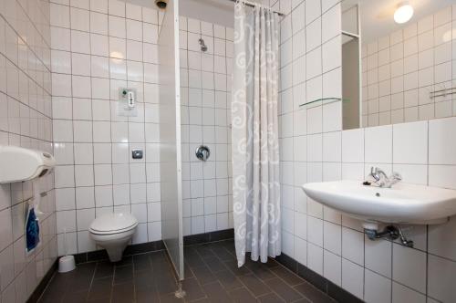 uma casa de banho com um WC, um lavatório e um chuveiro em Løgballe Camping & Cottages em Stouby