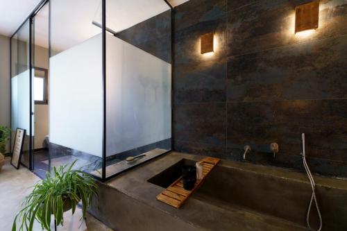 a bathroom with a bath tub with a sink at גלילה - סוויטת בוטיק רומנטיות לזוגות עם האט טאב פרטי ליד הים in Bustan HaGalil