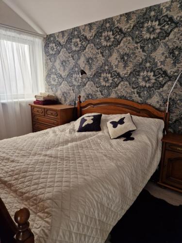 um quarto com uma cama com duas almofadas em Zauerveino apartamentai em Klaipėda
