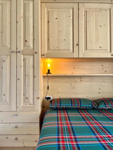 a bedroom with a bed with a wooden wall at Pizzo Stella - appartamento con box in Campodolcino