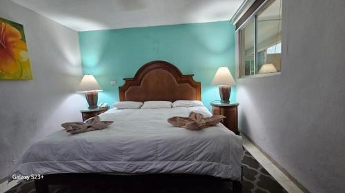 a bedroom with a large bed with two lamps at Grand Hotel Colonial Cancun in Cancún