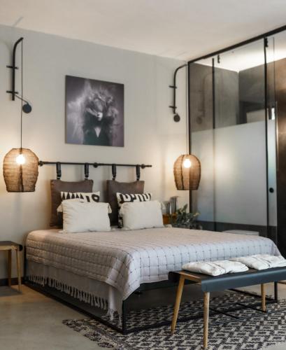 a bedroom with a large bed and two lamps at גלילה in Bustan HaGalil