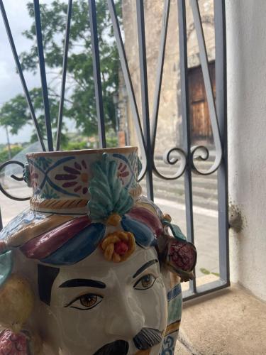 a statue of a woman with a hat on a window at Bed and Relax-Il Maniero in Calatabiano