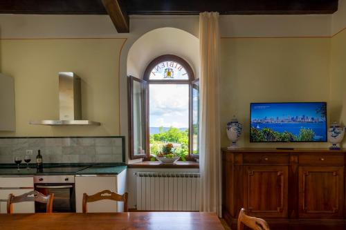 una cocina con ventana y un armario de madera con TV en IBibiena - CASA CAMPALDINO, en Poppi