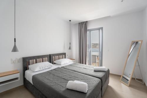 a bedroom with a large bed and a mirror at Liana sunset in Mikonos